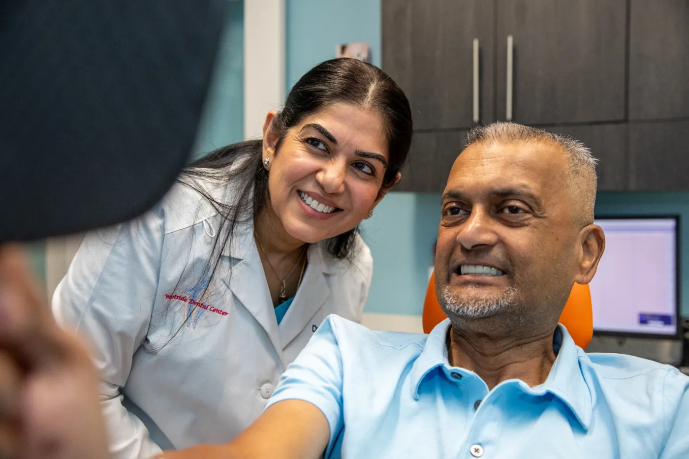 Patient smiling with Dr. Dham after treatment